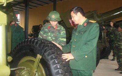 Đại tá Đặng Mạnh Hùng trao đổi nghiệp vụ bảo quản pháo với nhân viên kỹ thuật của lữ đoàn 168
